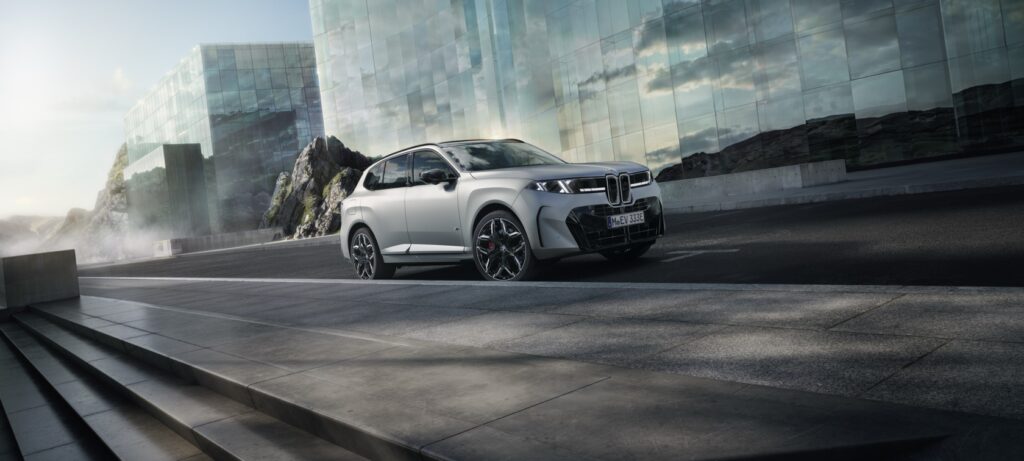 Der neue BMW X5 in Weiß vor einer modernen Glasfassade