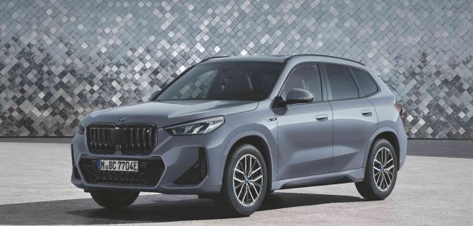 Silberner BMW iX1 xDrive30, geparkt vor einer geometrisch gemusterten Wand – ein echtes Fokusmodell auf GK-Niveau. Silberner BMW iX1 xDrive30, geparkt vor einer geometrisch gemusterten Wand - ein echtes Fokusmodell auf GK-Niveau.